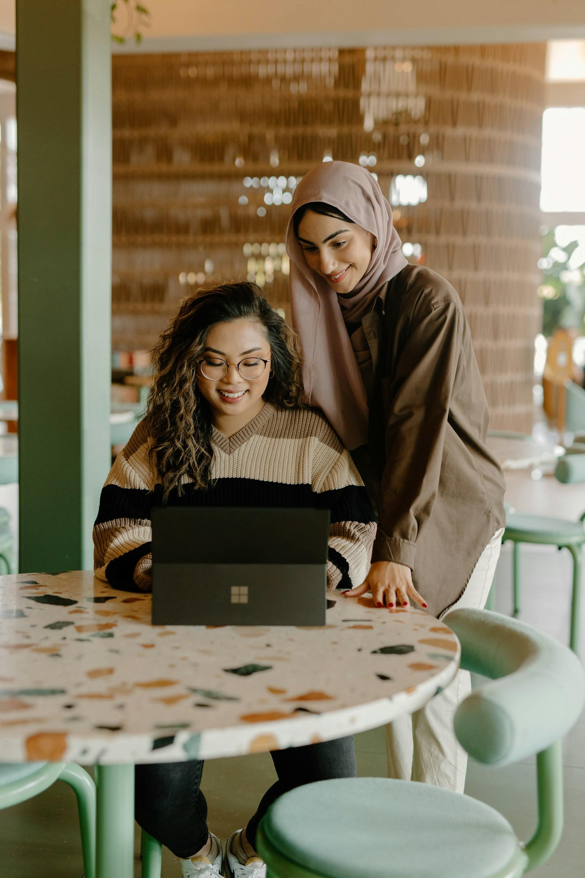 Two ladies looking at a laptop and smiling